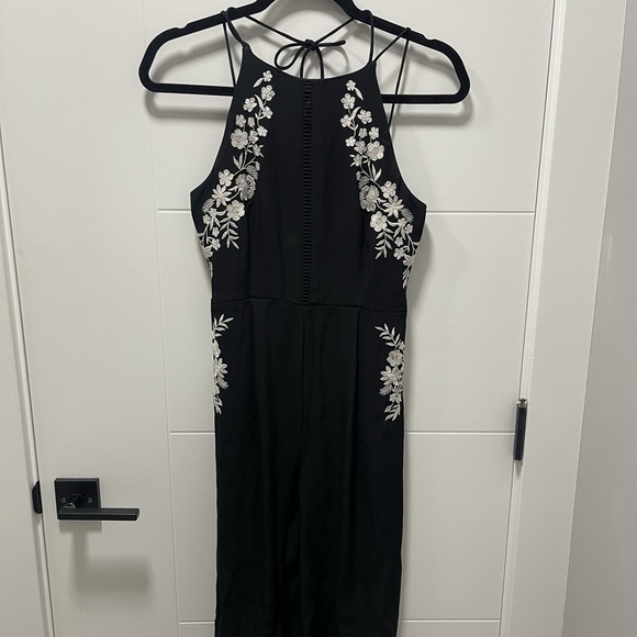 Black romper with white floral detailing. - Picture 2 of 3